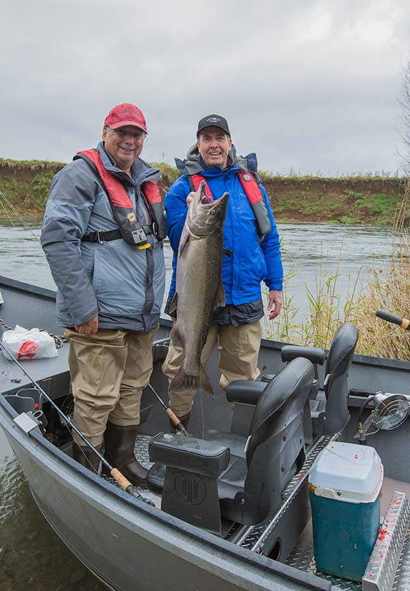 a couple guys holding a nice fall chinook from the trask river
